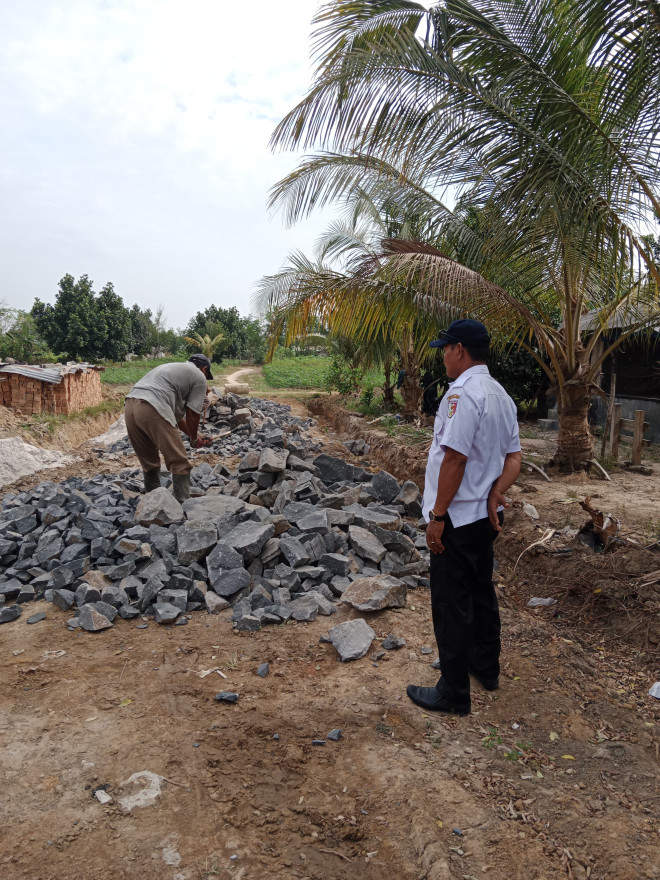 Pemasangan Batu Jalan di RW 01 Diawasi Langsung oleh Kepala Kampung Warga Indah Jaya